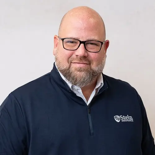 a man wearing glasses and a blue jacket